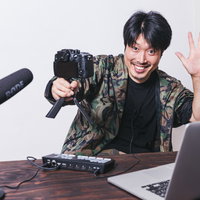 一眼カメラを使って自撮り撮影する男性のポートレートの写真