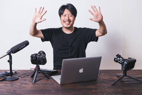 視聴者に手を振るムービー撮影中の男性配信者