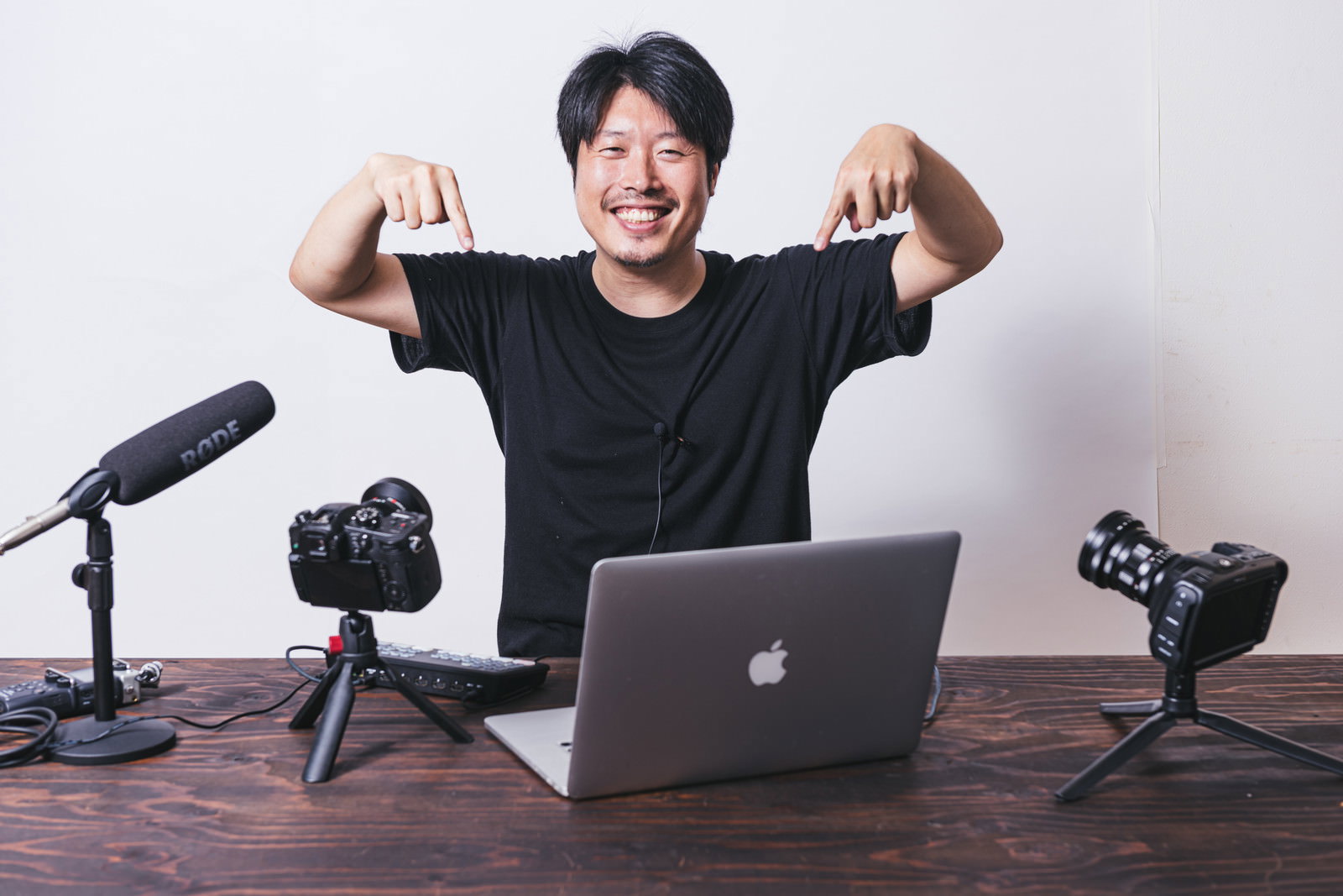 指をさして笑顔を見せる動画配信者の男性［モデル：瀧野恵太］