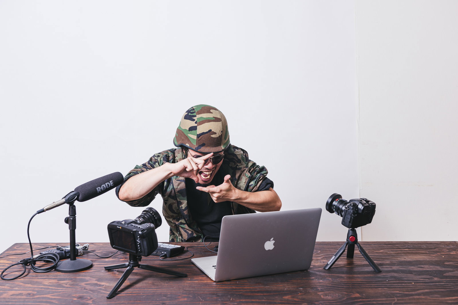 ノートパソコンを見ながら手でフレーミングを作るYouTuber男性［モデル：瀧野恵太］