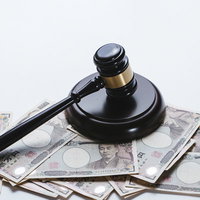 大人の力で成立する売買と法的決定の象徴である木槌と札束の写真