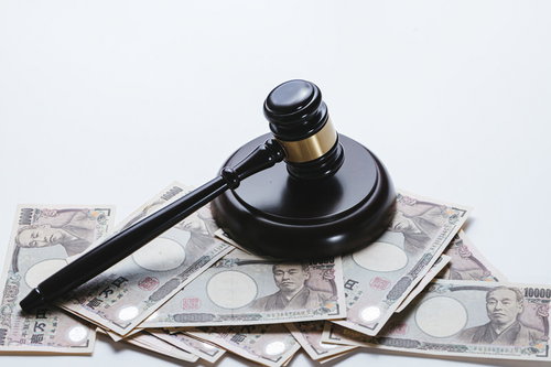 大人の力で成立する売買と法的決定の象徴である木槌と札束