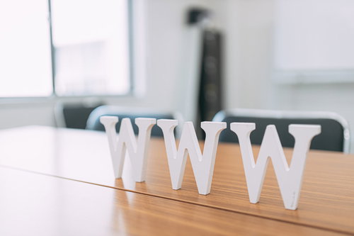木製テーブルに置かれたWWWの白いアルファベットオブジェ
