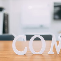 白いCOM立体文字でドメイン取得をイメージした.comのドメインの写真