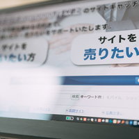 パソコンのモニターに表示されたサイト売買仲介のWebサービス画面の写真