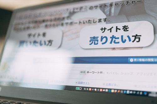 パソコンのモニターに表示されたサイト売買仲介のWebサービス画面
