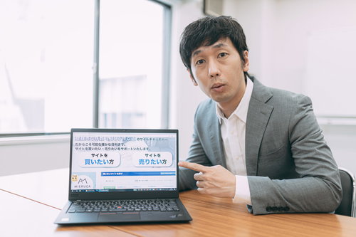 副業でドメイン売買について説明するスーツ姿の男性