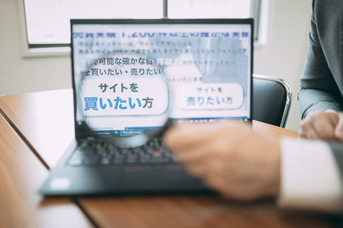 優良なサイトを買いたい方へ、ノートパソコンで情報確認する男性