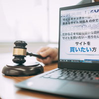 サイトの売却が成立しました、ガベルとノートパソコンの写真