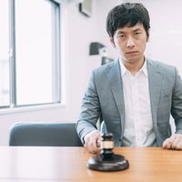 ガベルを手にして判断を下すビジネスマン、オフィスでの法的決定の写真
