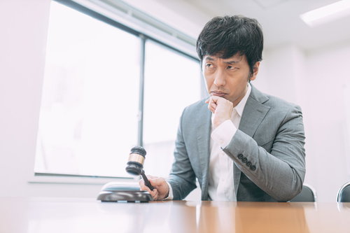 入札価格を下げるか悩むオークションのベテラン男性