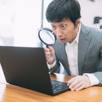 サイトの隅々までチェックを入れる管理人が虫眼鏡で鑑定の写真