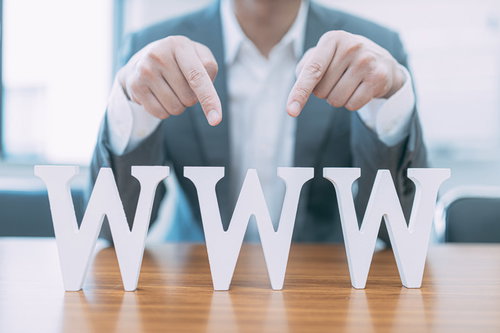 ｗｗｗ（ダブダブダブ）を指さすスーツのビジネスマン