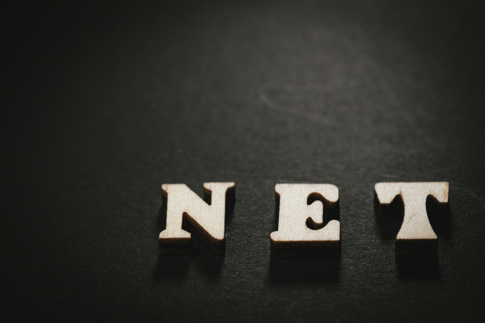 黒い背景に白い立体的な文字でNETと配置された英文字
