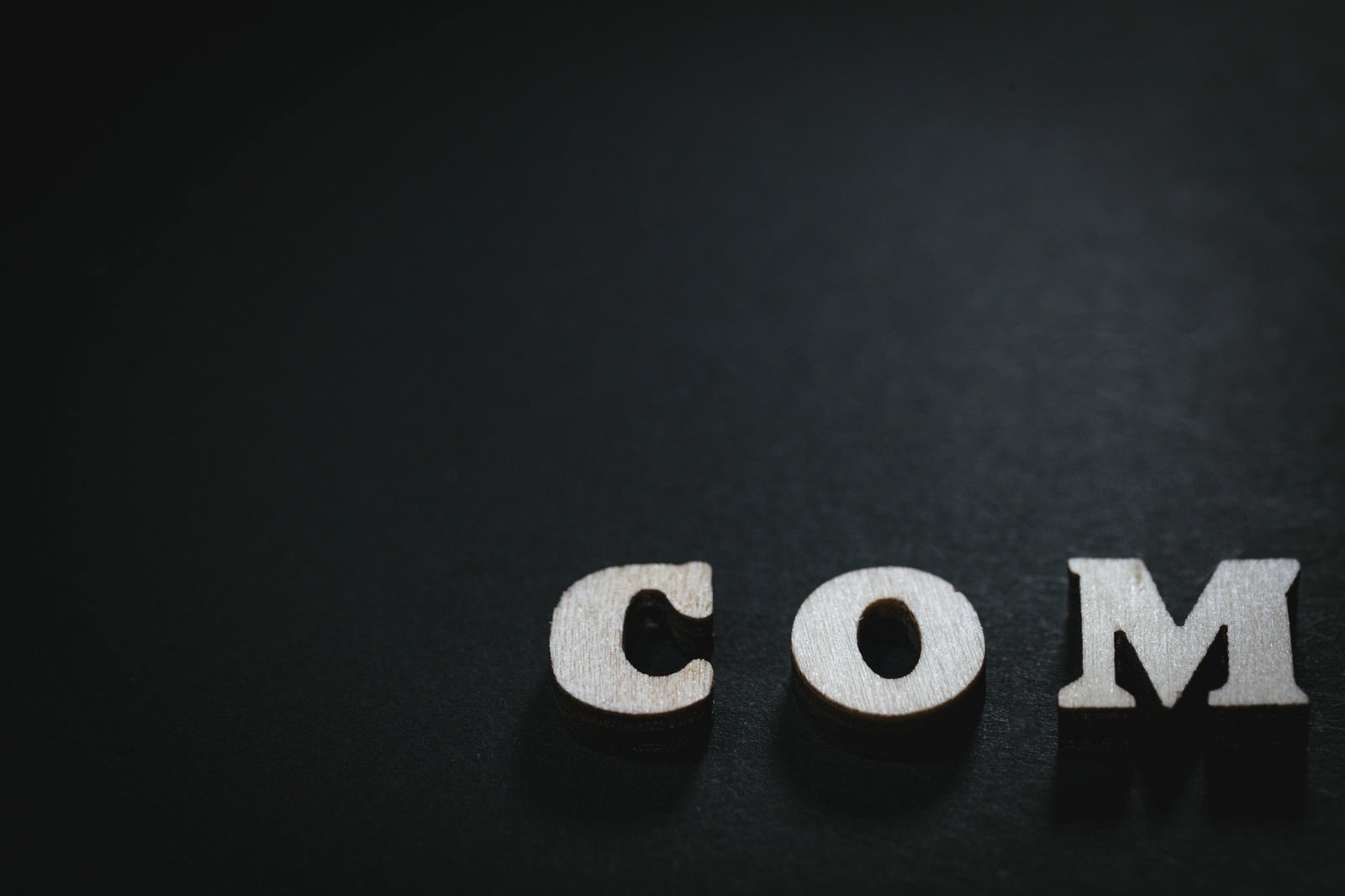 黒背景にCOMの木製文字駒が並ぶ