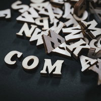 木製の英文字で作ったドットコムのドメイン名の写真