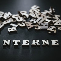 黒い背景に散らばるアルファベットとINTERNETの英文字の写真