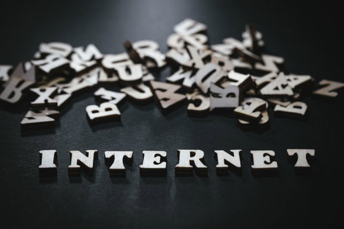 黒い背景に散らばるアルファベットとINTERNETの英文字