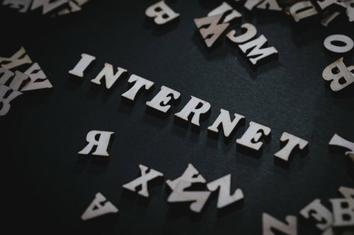 黒背景に白く映るINTERNETの文字と英文字が散らばるデザイン