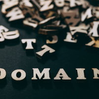 膨大なドメインと散らばる英文字、黒背景のゴールド立体アルファベットの写真