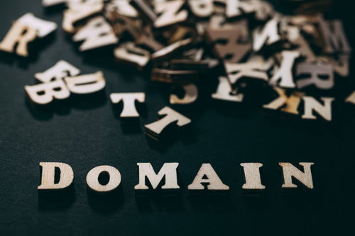 膨大なドメインと散らばる英文字、黒背景のゴールド立体アルファベット