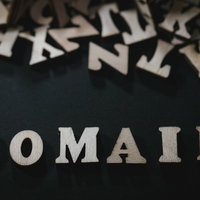 黒背景に散らばるアルファベットとDOMAINの文字の写真