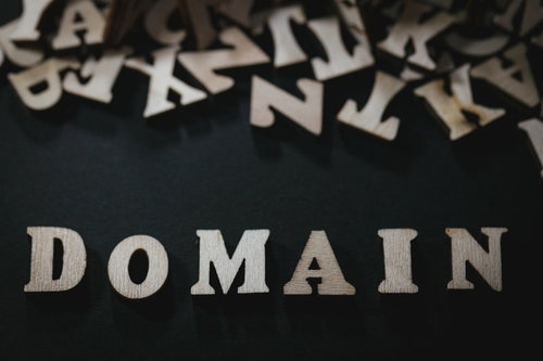 黒背景に散らばるアルファベットとDOMAINの文字