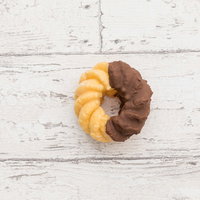 甘いチョコレートのフレンチクルーラー、白い木目背景に置かれた2色のドーナツの写真