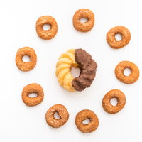 中央の大きなチョコドーナツを囲むカリスマドーナツの写真