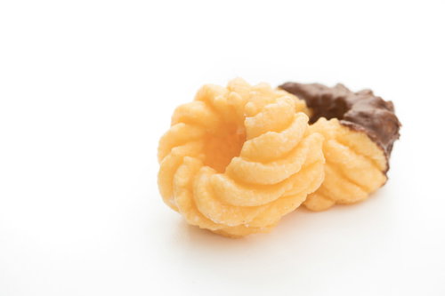 白い背景に置かれたさくさく甘いフレンチクルーラー