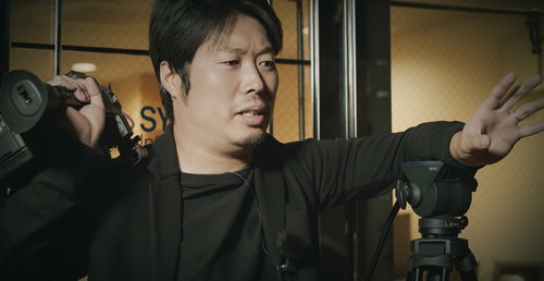 ビデオカメラを背負ってダメ出しする男性監督