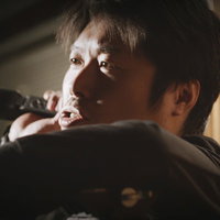 撮影現場でビデオカメラを操作する男性カメラマンの仕事風景の写真