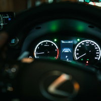 夜間走行中の車のスピードメーターとハンドルの写真