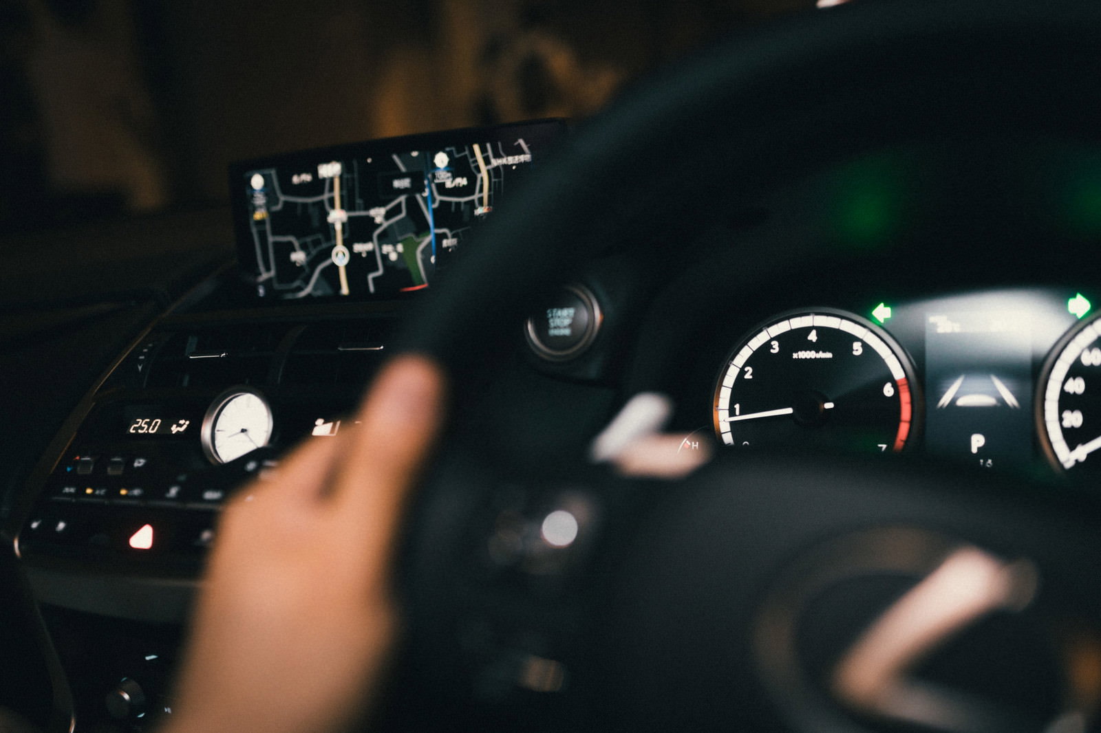 夜間の車内で運転席のハンドルとカーナビゲーション画面