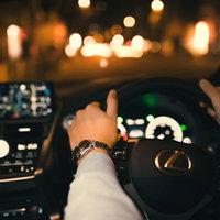 銀座の夜に走るタクシーと時計塔のある交差点の写真