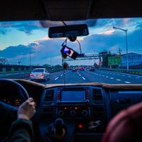 高速道路を走る運転席からの景色と運転者の手元の写真