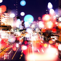 ネオン光が降り注ぐ夜の街並み（フォトモンタージュ）の写真