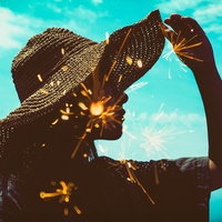 麦わら帽子と線香花火が重なる暑い日差しのフォトモンタージュの写真