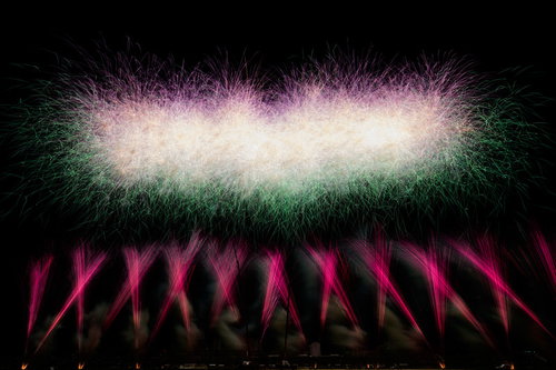 目の前に広がるスターマイン花火の光跡と火の粉