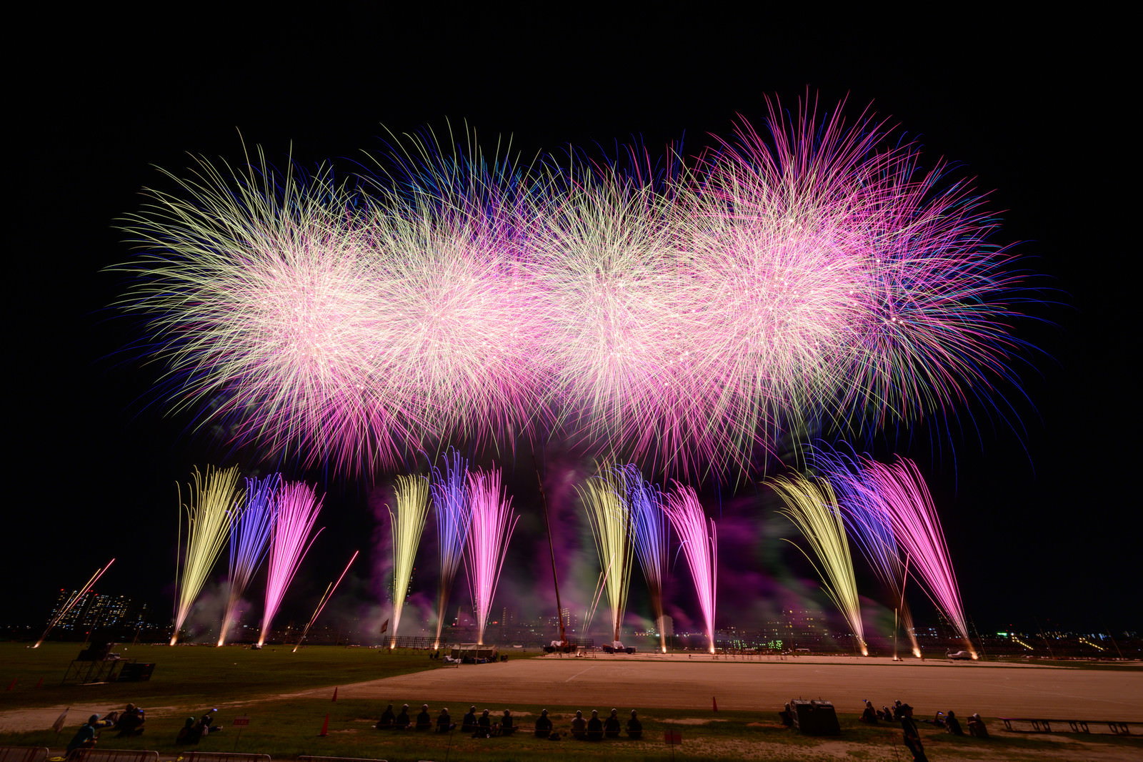 夜空に咲くピンクと紫色のスターマイン花火