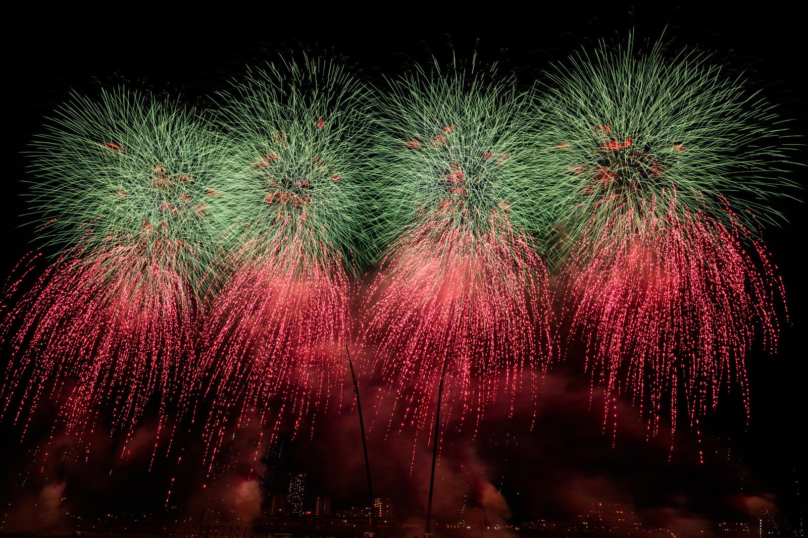 夜空に赤と緑の鮮やかな色で大きく広がる打上花火
