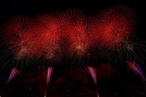 赤く弾ける打上花火が夜空に連続して広がる光景