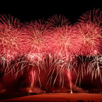 夜空を赤く染める迫力のあるスターマインの花火の写真