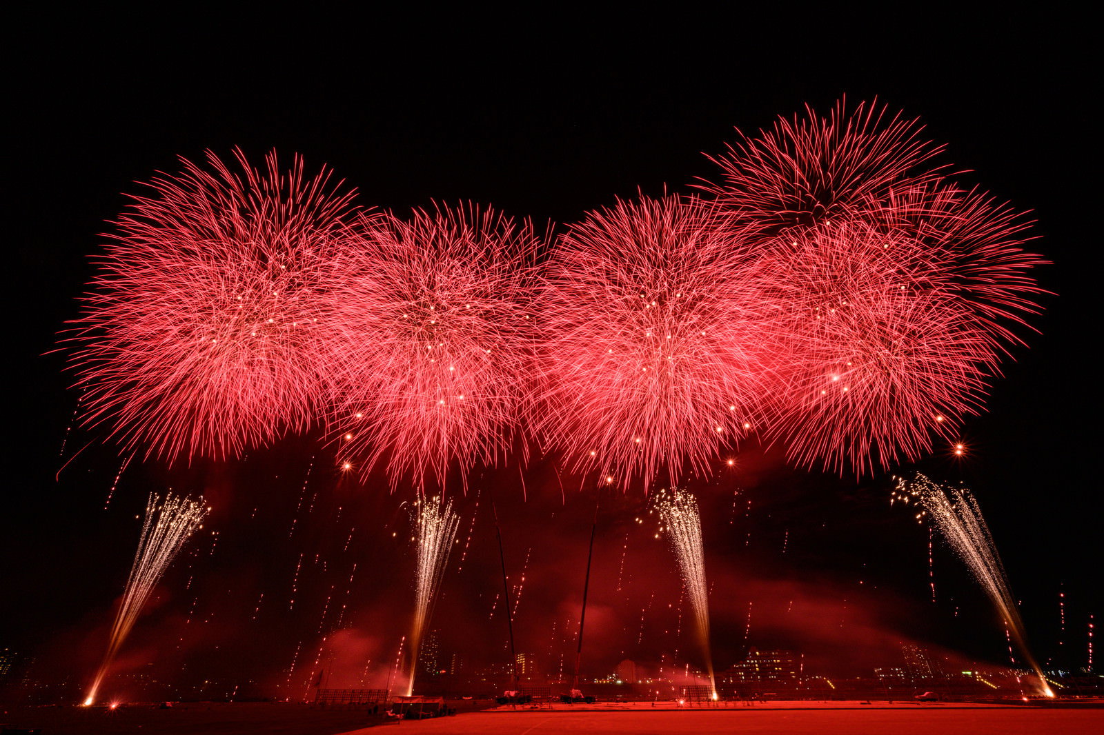江戸川区花火大会で赤い光が夜空を染めるスターマインの花火