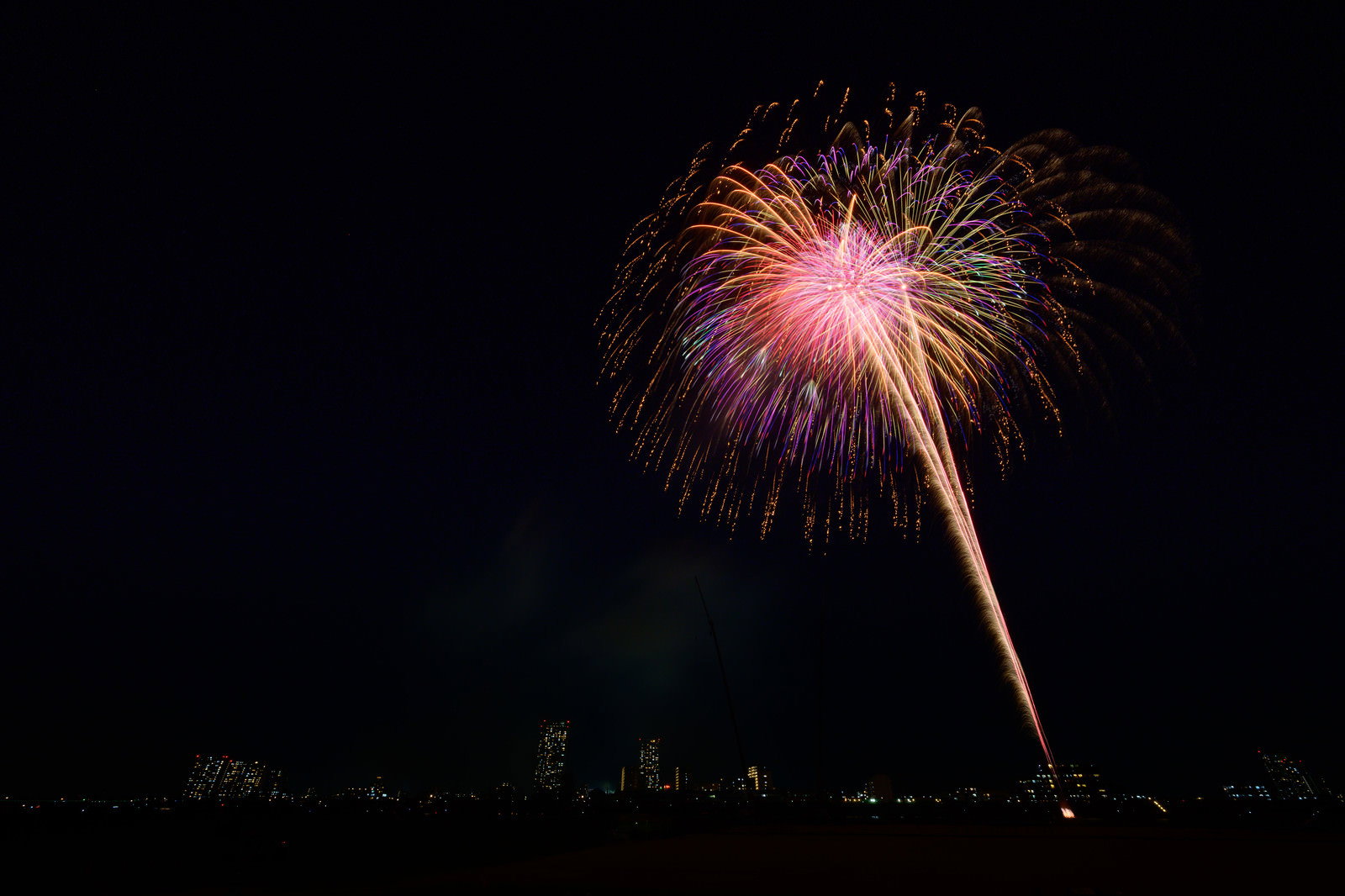 夜空に色とりどりの光を放射状に広げる打ち上げ花火