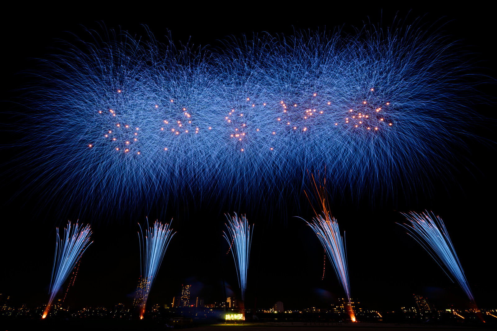 夜空に青く炸裂するスターマインの花火