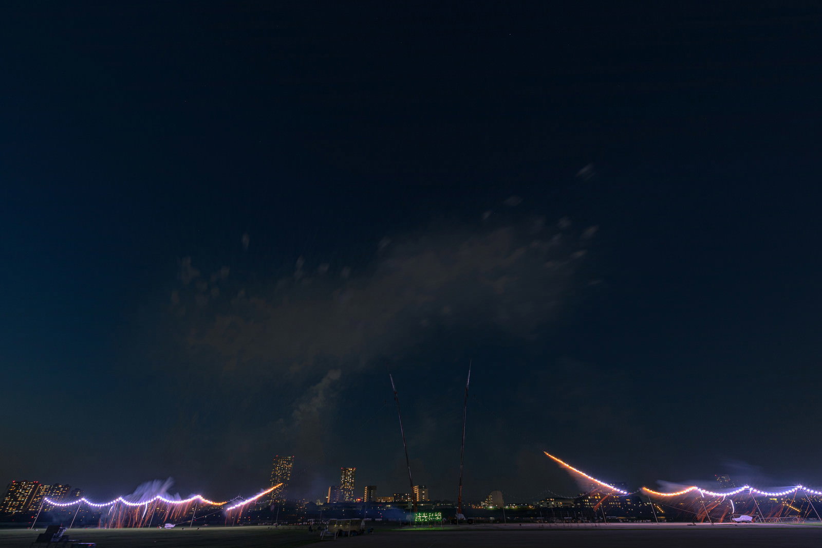 江戸川区花火大会で仕掛け花火に点火する様子と夜空に輝く星空