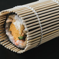竹製の巻き簾の上に置かれた海苔巻と太巻きの写真