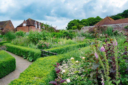 緑いっぱいの庭園と古い邸宅のレンガ造りの家