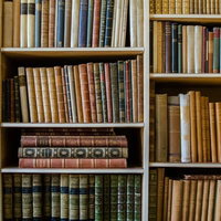 古書が並ぶ図書館の本棚、革装本と文庫本が整然と配置された書架の写真